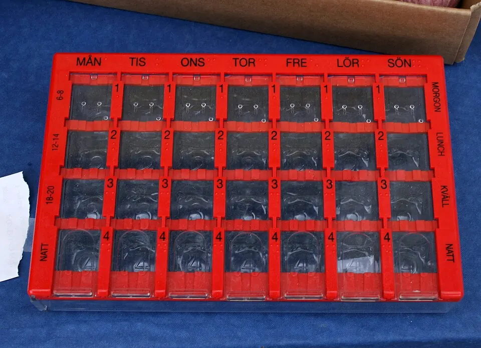 Pilulier rouge avec compartiments pour organiser des médicaments